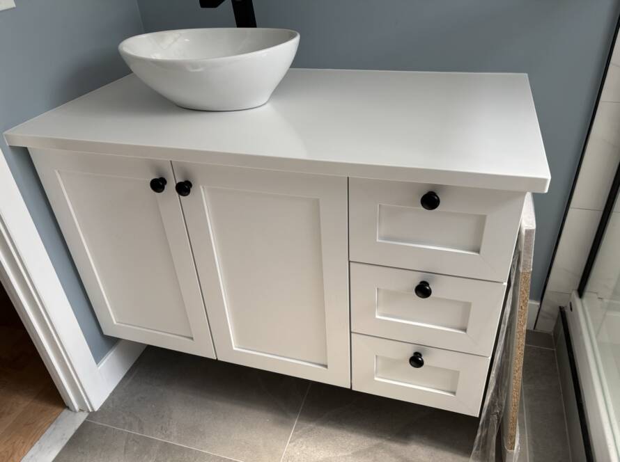 Salle de bain aménagée au sous-sol avec rangement sur mesure